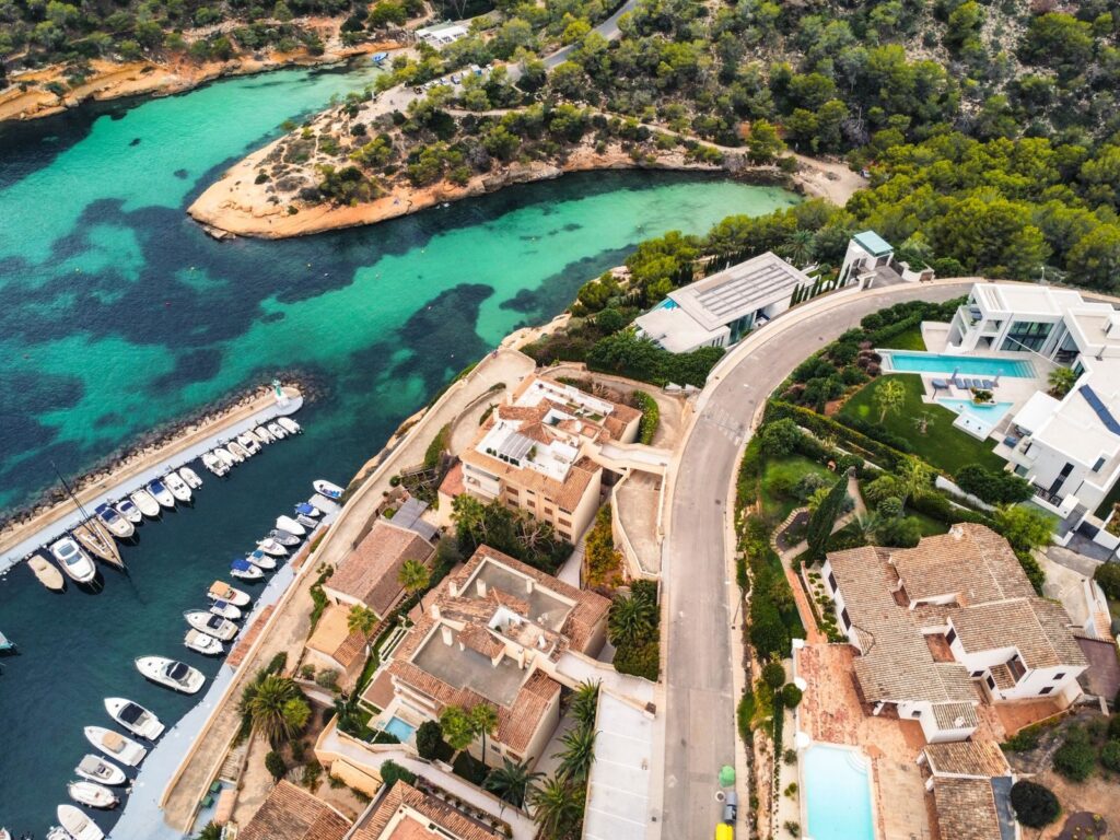Photo by Artur T. Aerial shot of luxury coastal homes, marina, and turquoise waters.