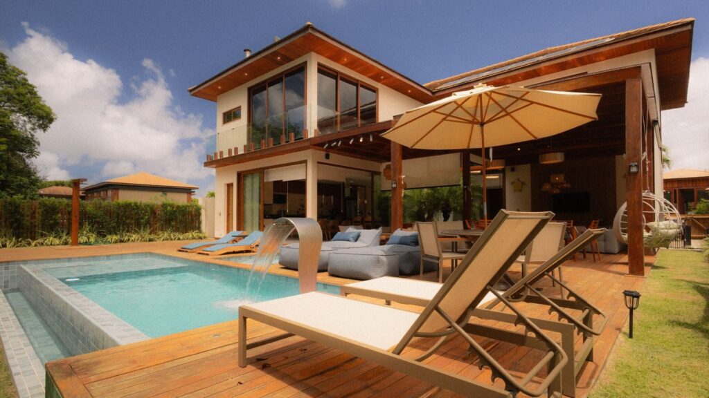 Photo by Alef Morais Elegant villa featuring a private pool and sun loungers for ultimate relaxation.