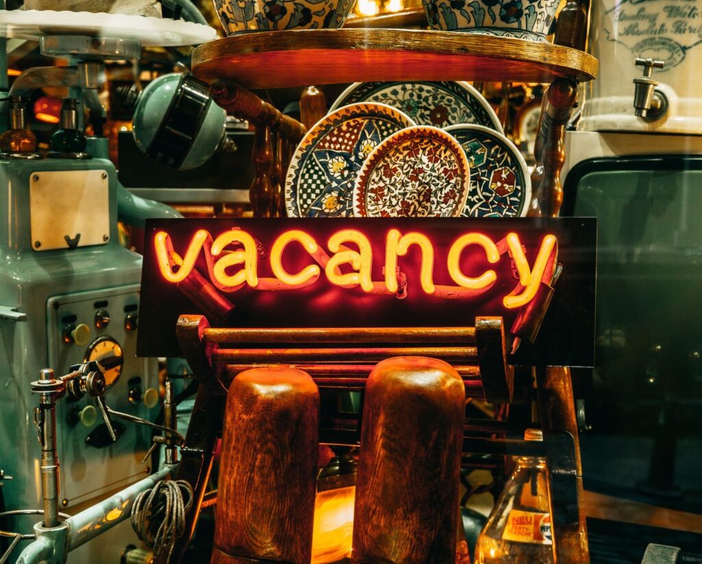 Vintage Istanbul decor featuring a neon 'Vacancy' sign surrounded by retro items and colorful ceramic plates.
