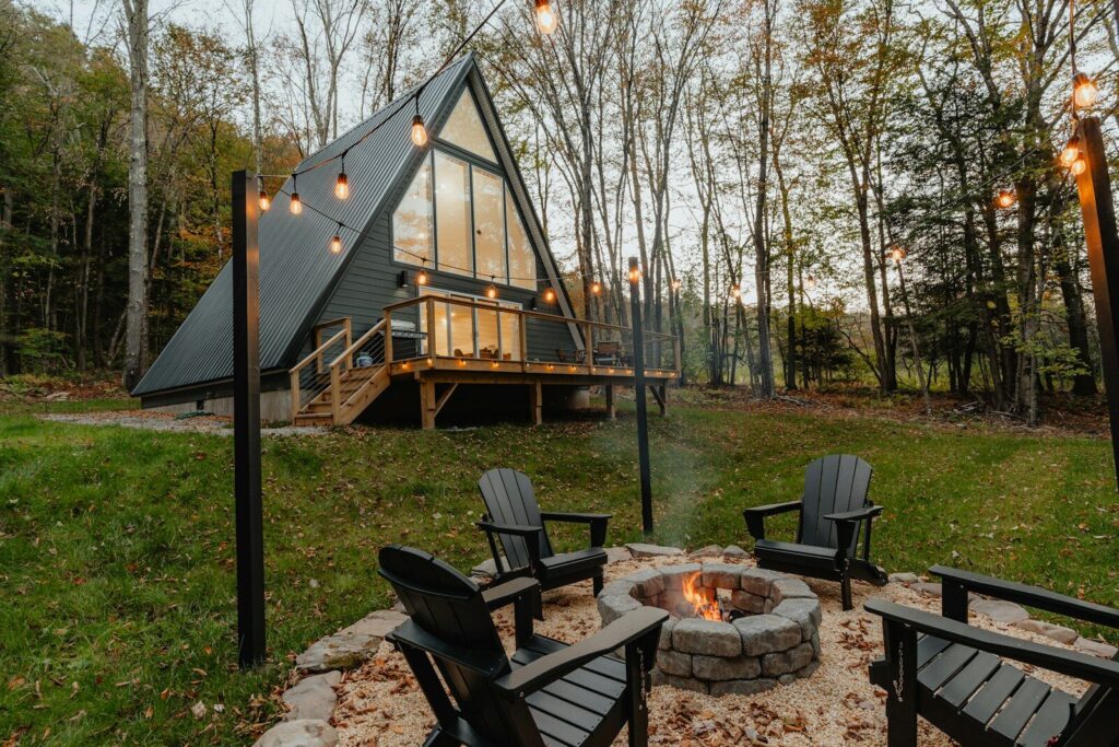Photo by Clay Banks a small cabin with a fire pit in the yard